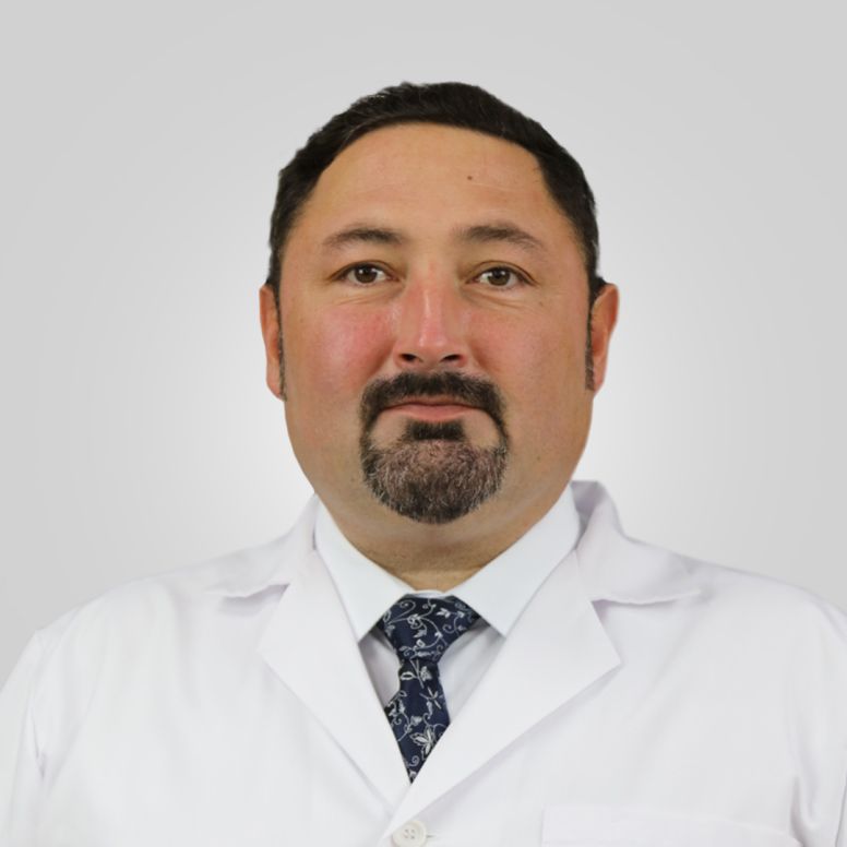 MUA Professor Volodymyr Ikramov standing in the library wearing lab coat.